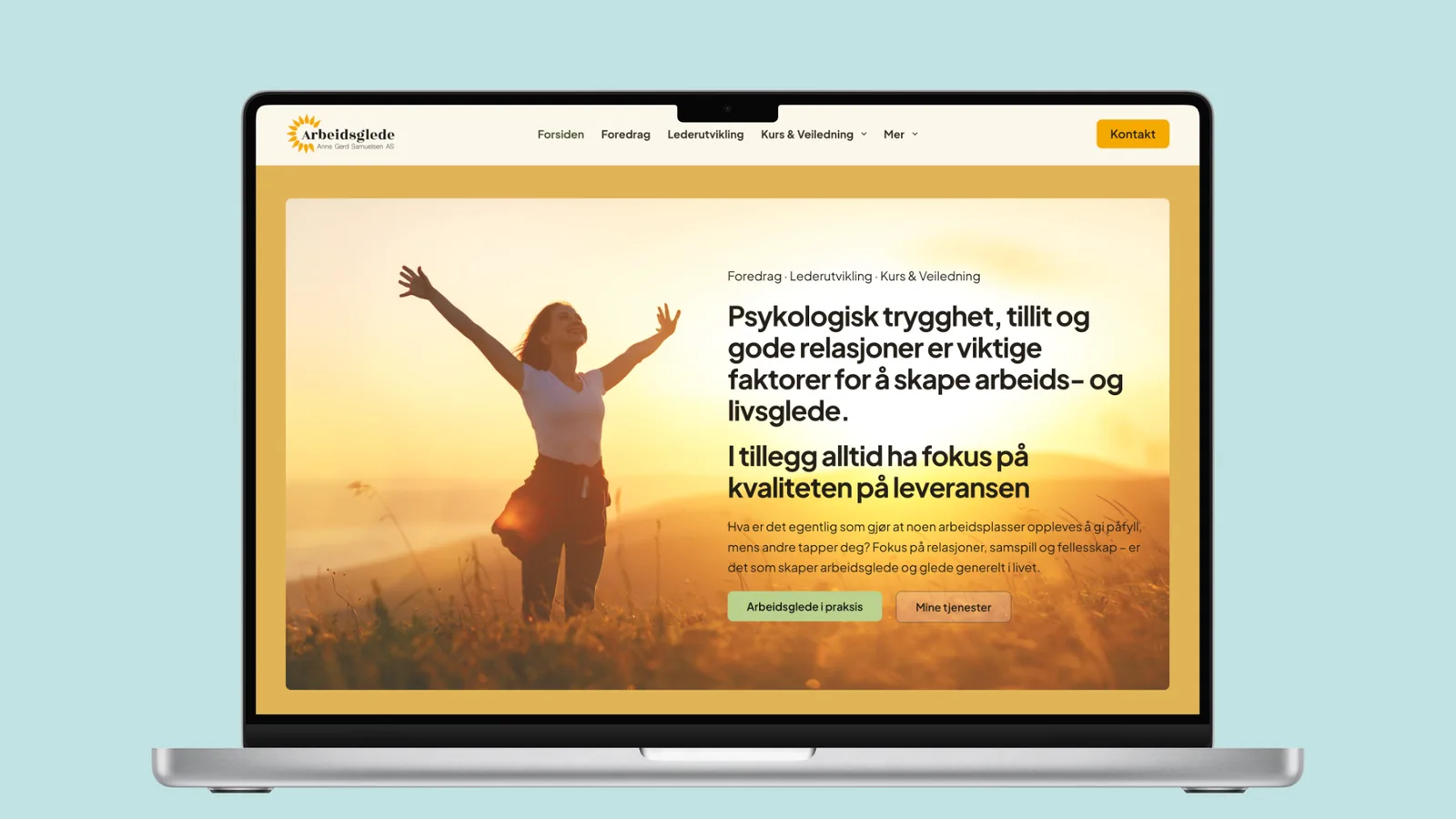 Forsiden av arbeidsglede.com vist på en laptop, med en kvinne som strekker armene ut i et solbelyst landskap ved siden av overskriften «Psykologisk trygghet, tillit og gode relasjoner er viktige faktorer for å skape arbeids- og livsglede.» og knappene «Arbeidsglede i praksis» og «Mine tjenester».
